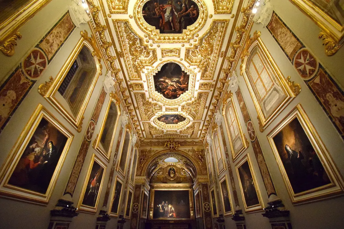 The Oratory of St John's Co-Cathedral, a narrow gilded hall hung with large paintings, with Caravaggio's Beheading of Saint John the Baptist at the far end